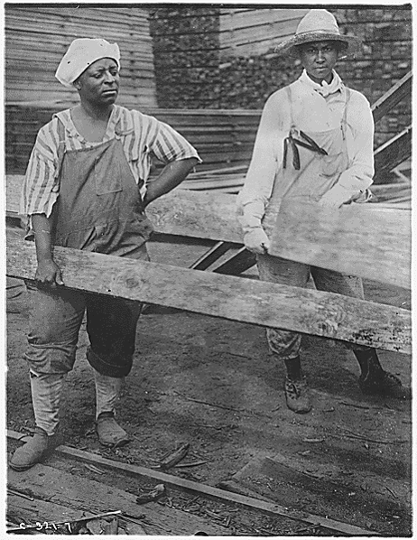 Labor. [African-American] women at work in lumber yards. [African-American] women, dressed in men's clothes, lifting heavy pieces of lumber