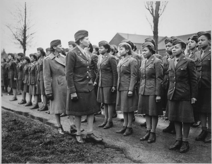Black and white photograph of a group of WAC members standing at attention during inspection by officers
