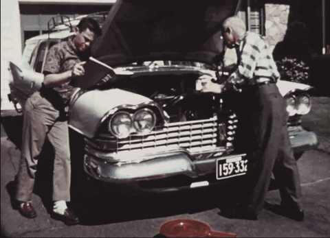 vintage footage of two people repairing a car