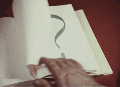 Animated GIF of a book with a large question mark on each page. A hand turns the page to reveal a new question mark on the next page
